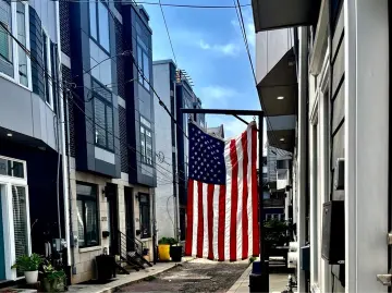 Street view featuring a USA flag waving, symbolizing citizenship preparation.