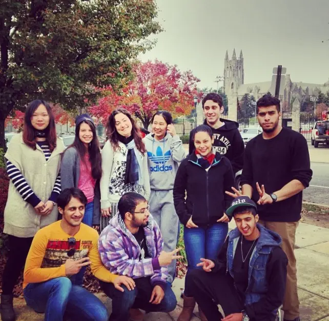 Maria and her students gathered for a group photo in an urban city setting, preparing for English test success.